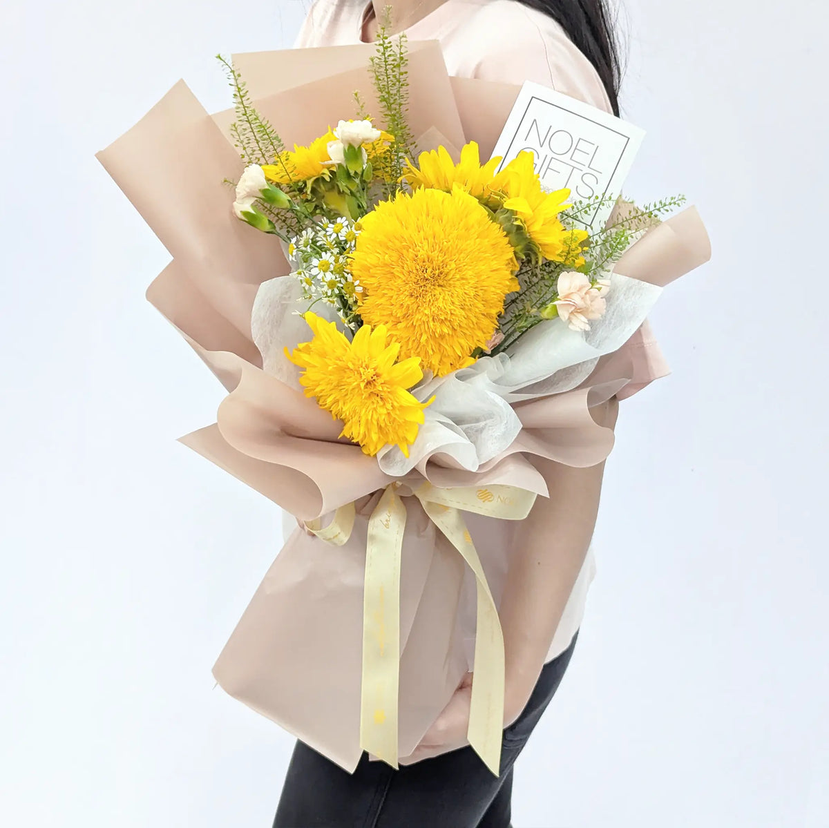 Woman receiving Sunshine Hugs Petite Hand Bouquet with Teddy Bear Sunflowers