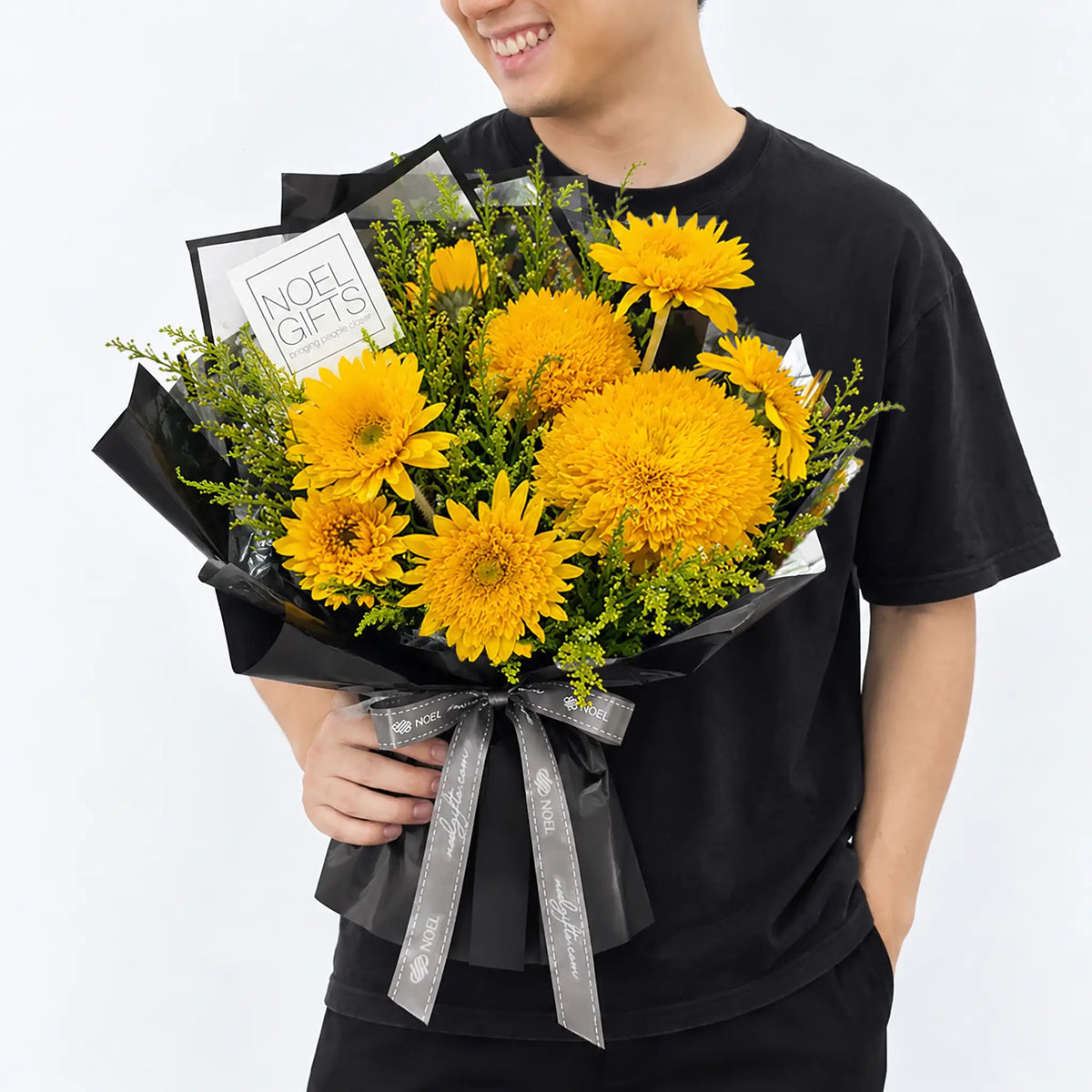 Man holding Born to Shine Petite Hand Bouquet with golden teddy bear sunflowers and yellow phoenix