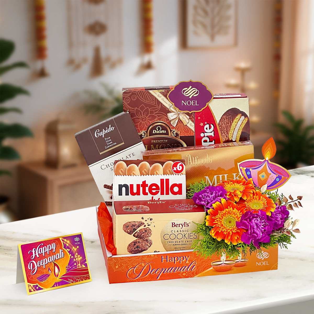 Deepavali Chocolate Blossom Gift Box with assorted chocolates, cookies, orange gerbera, purple carnation and golden leaf